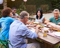 Image of individuals smiling and laughing around table