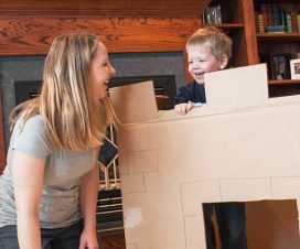 Mom playing with son in cardboard box