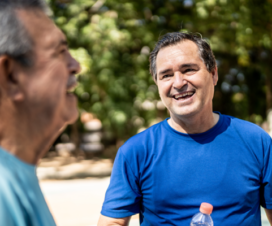 Middle-aged man in blue shirt standing outside smiling.
