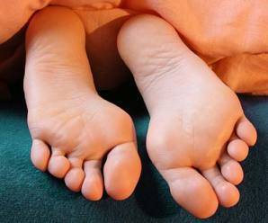 Teenager's feet sticking out of bed covers