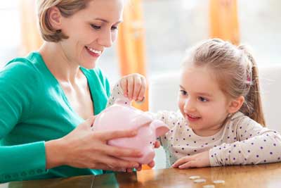 Mother and Daughter putting money into a piggy bank