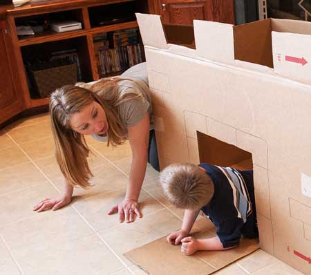 Mom playing with her son in a cardboard box fort - Indoor activities for kids