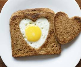 Egg cooked in toast's heart-shaped hole on plate