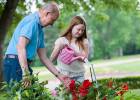 Girl watering flowers with Grandpa