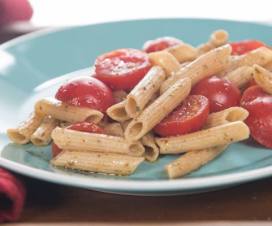 Plate of penne pasta with pesto and cherry tomatoes