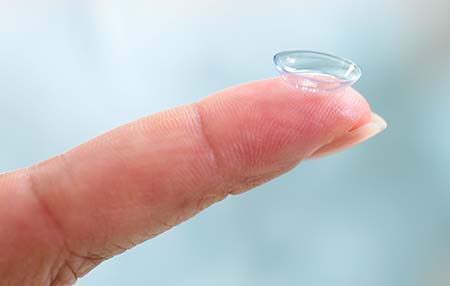 Woman holding contact lens on her finger