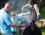 boy watching his dad baste food on the grill with marinade