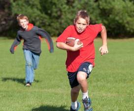 boys running outside with a football