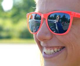 Grinning woman in the sun wearing sunglasses
