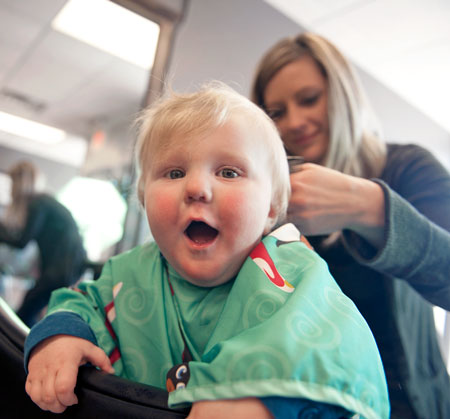 baby with cute face getting first hair cut