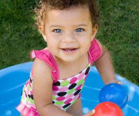 smiling girl in a kiddie pool