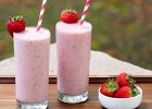 Two glasses of strawberry banana smoothies sitting on a tray