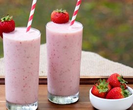 Two glasses of strawberry banana smoothies sitting on a tray