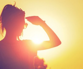 woman standing in bright sun, wondering about sun allergy.