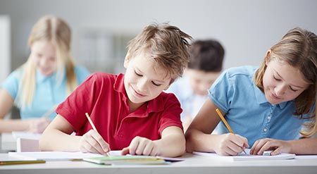 Boy and girl with ADHD doing school work in classroom