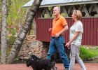 couple walking their dogs next to a covered bridge