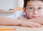 boy with glasses at his desk at school
