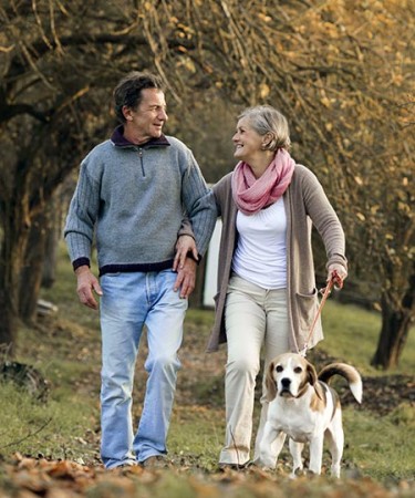 Man and woman walking outside with dog to prevent deep vein thrombosis