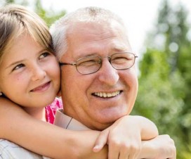 Young girl hugging grandpa around his neck