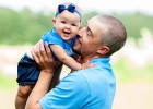 Smiling dad holding baby daughter in air, close to face