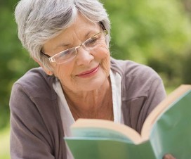 Woman reading a book outside - do you need cataract surgery?