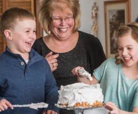 Grandkids helping Grandma frost a cake