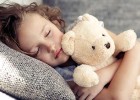 Young girl napping on sofa holding teddy bear - Do your kids need a nap?