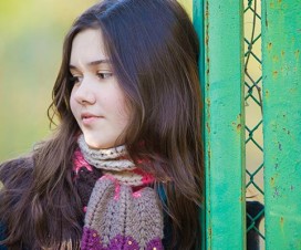 Teenage girl leaning against a fence - Adolescent health and heart disease