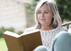 Woman sitting outside, reading a book - defining secondary cancer