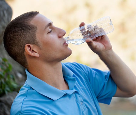 Man taking a drink of water while hiking
