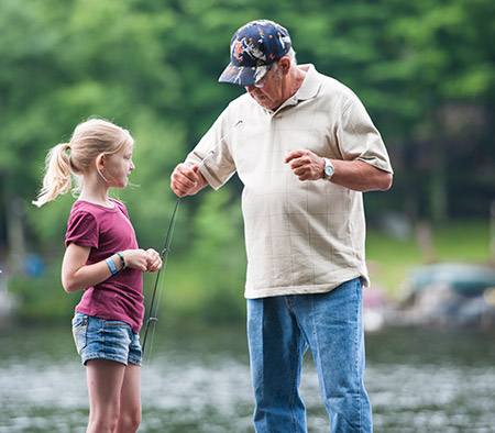 Grandpa setting up fishing pole for granddaughter - first aid Fishing Safety