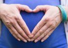 Woman making a heart with her hands over her pregnant belly - Heart health and pregnancy