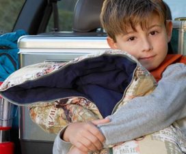 Kid with sleeping bag in front of packed car - Calming kid's fears of being away from home at summer camp