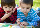 Two boys reading outside on a summer day - Keeping up school skills during the summer
