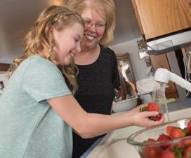Grandma and granddaughter washing strawberries - Healthy habits