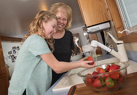 Grandma and granddaughter washing strawberries - Healthy habits