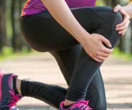 Woman holding shins after running with a stress fracture in her legs