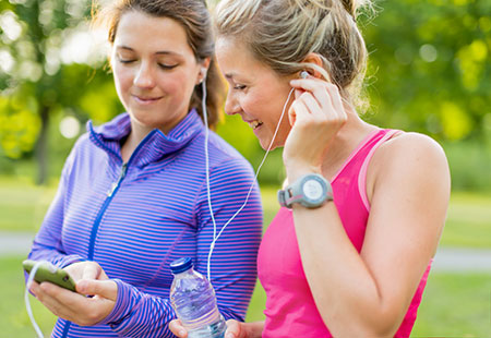 Two women listening to music as they get ready to exercise - Behaviors to beat depression