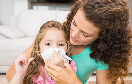 Mom helping daughter blow her nose - Prepping kids for cold and flu season