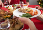 Person holding their plate up to be served turkey at a holiday dinner - Holiday moderation
