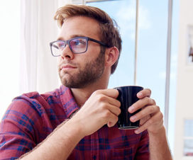 Young man drinking coffee - Testicular self-exam