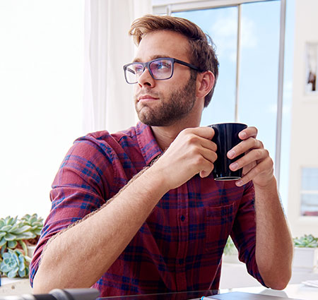 Young man drinking coffee - Testicular self-exam