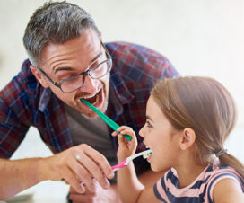Dad and daughter brushing teeth