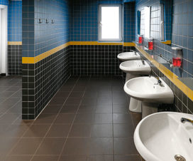 Blue and black tiled public bathroom