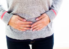 Woman having cramps, holding her belly
