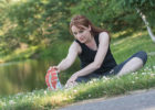 Woman stretching in grass - Sore muscles