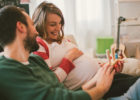 Father and pregnant mother laughing and holding a baby toy - What to expect in the 2nd trimester