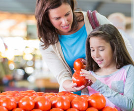 Mom and daughter grocery shopping looking at tomatoes - Food labels and buzzwords