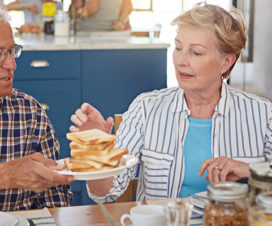 Senior man and senior woman having breakfast, passing a plate stacked with toast - Diabetes and your bones