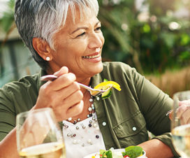 Senior woman eating salad on the patio - Food to reduce joint pain
